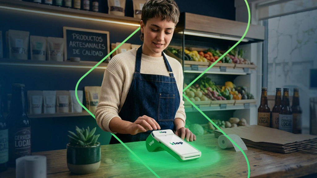 Comerciante atendiendo en un almacén con un POS Klap y las estanterías llenas de mercadería